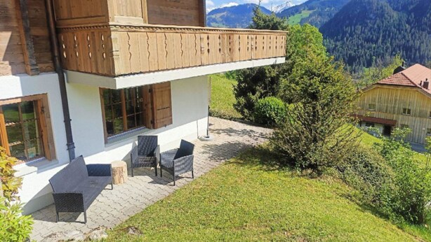 Una cabaña de madera con balcón que domina un paisaje montañoso.