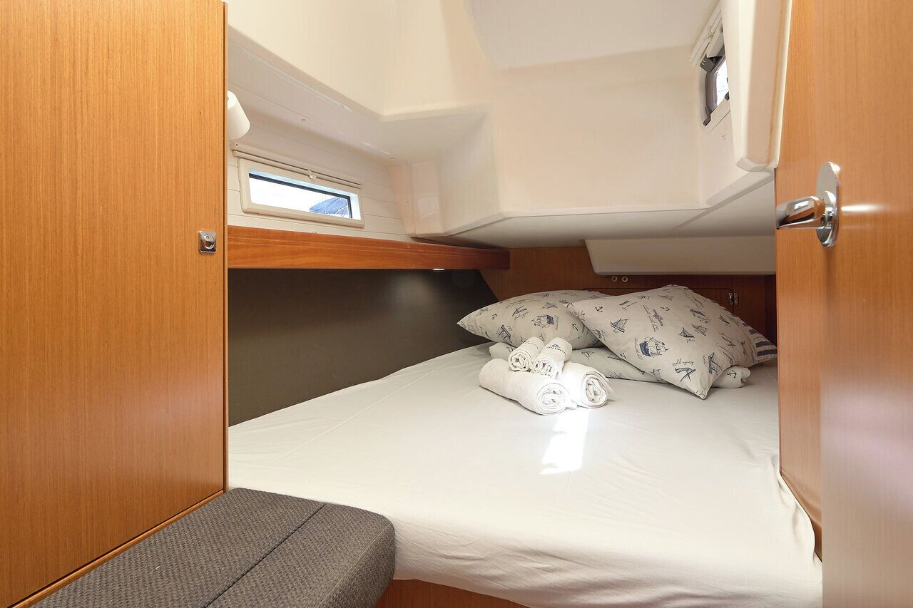 A compact cabin with a bed, a small window, and a door.