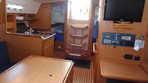 A compact interior with a kitchenette, a TV, and a seating area.