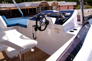 Bootinterieur met stuurwiel, bedieningspaneel en zithoek.