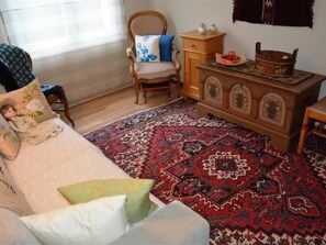 A room with a bed, a chair, a wooden dresser, and a patterned rug. - Hübeli (Arm) Appartement/Fewo, Dusche oder Bad, WC 4-Bettwohnung by Interhome (Zweisimmen)