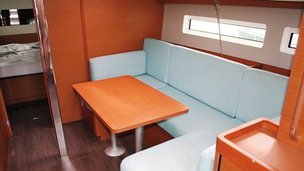 A compact, well-lit interior with a wooden table and light blue cushioned seating. - Dubrovnik Delight: A Sun-Kissed Sailing Experience (Komolac)