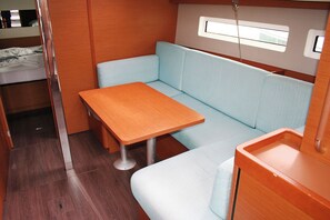 Un intérieur compact et bien éclairé, avec une table en bois et des sièges rembourrés de couleur bleu clair.