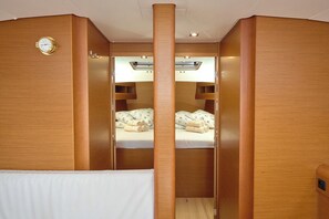 Uma cabana com paredes de madeira, uma cama beliche, um relógio e uma pequena prateleira.