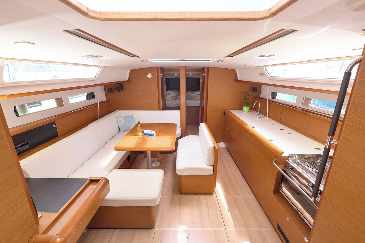 A compact, well-lit interior with a dining area, seating, and a kitchenette.