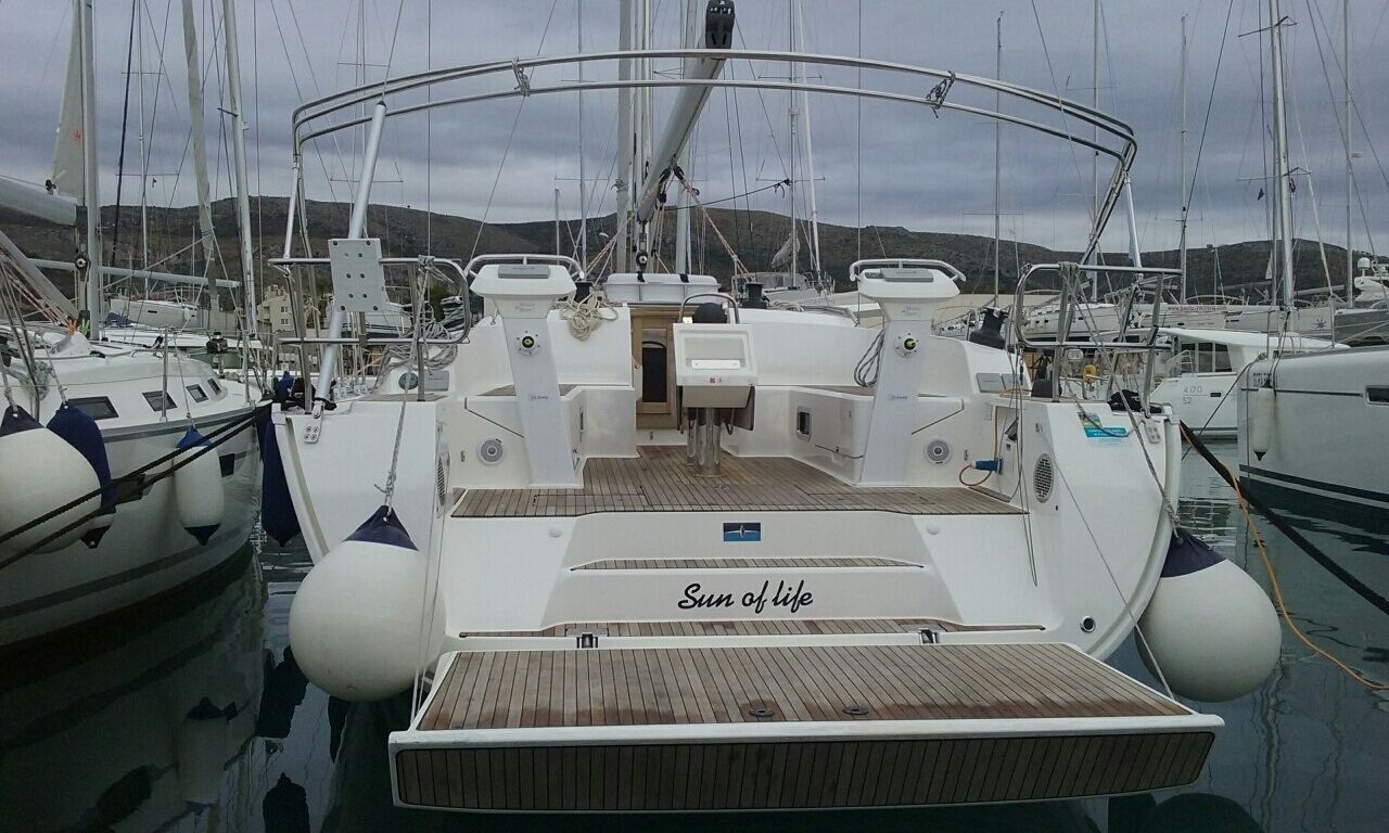 A marina with boats docked, a wooden deck, and a cabin with 'Sun of life' on the side.