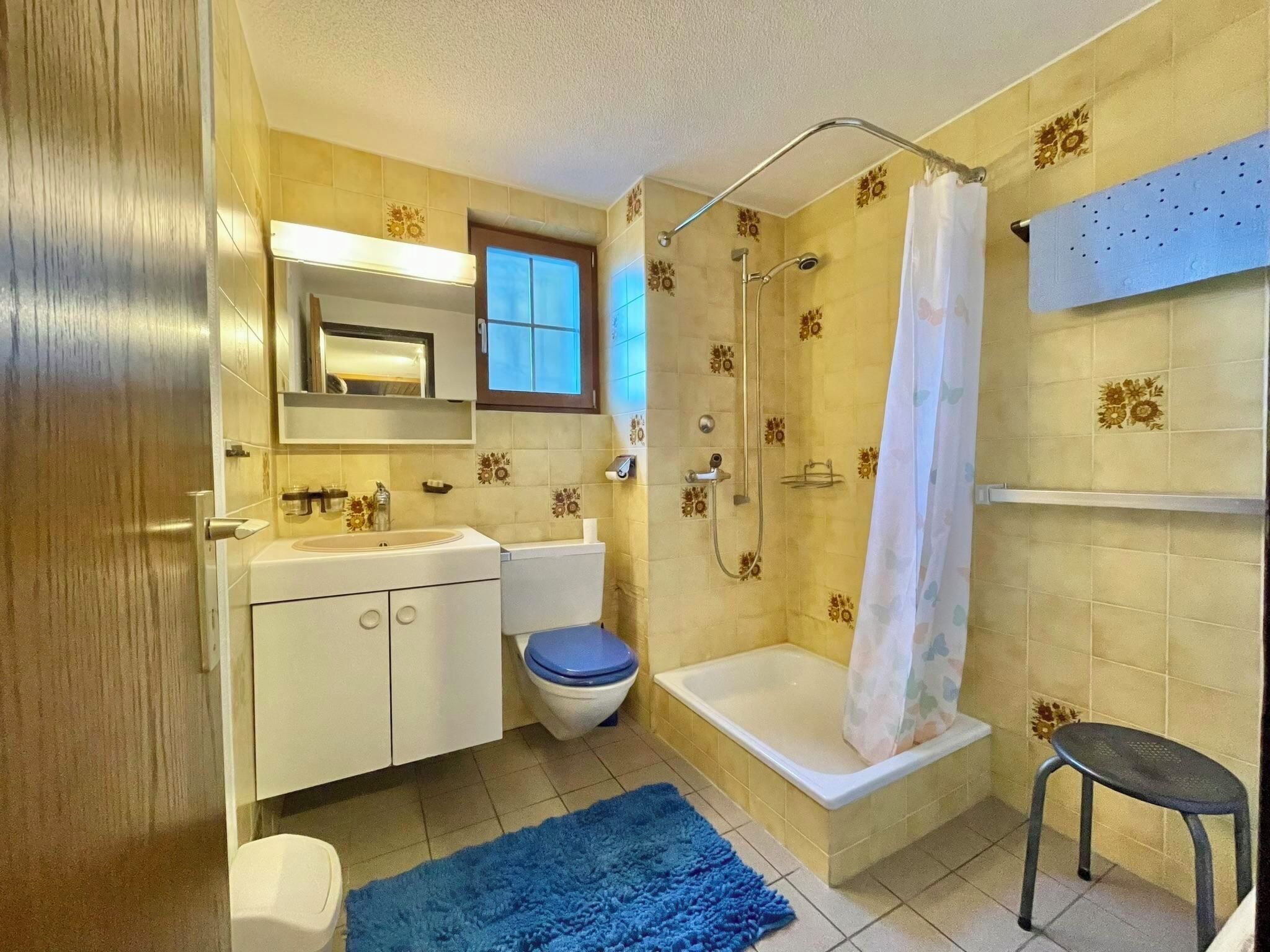 Une salle de bain équipée d’une douche, de toilettes, d’un lavabo et d’un miroir.