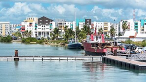 A marina with boats docked, a pier, and a row of colorful buildings in the background.