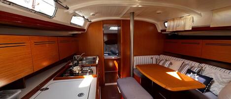 A compact galley with a stove, sink, and bench seating.