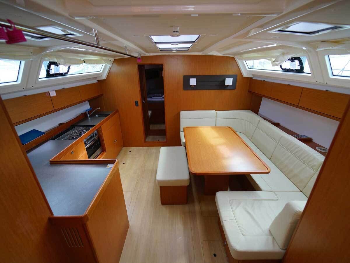 Un intérieur de camping-car compact comprenant un coin cuisine, un espace repas et un coin salon.
