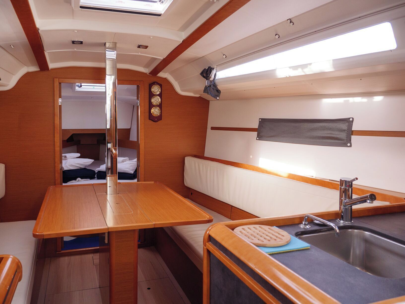 A compact galley with a wooden table, bench, and sink.