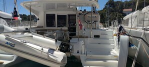 A marina with boats docked, including a white boat with 'ARIMAR' branding and a motor. - Sun-Kissed Sailing Adventure in Split, Croatia (Rogac)