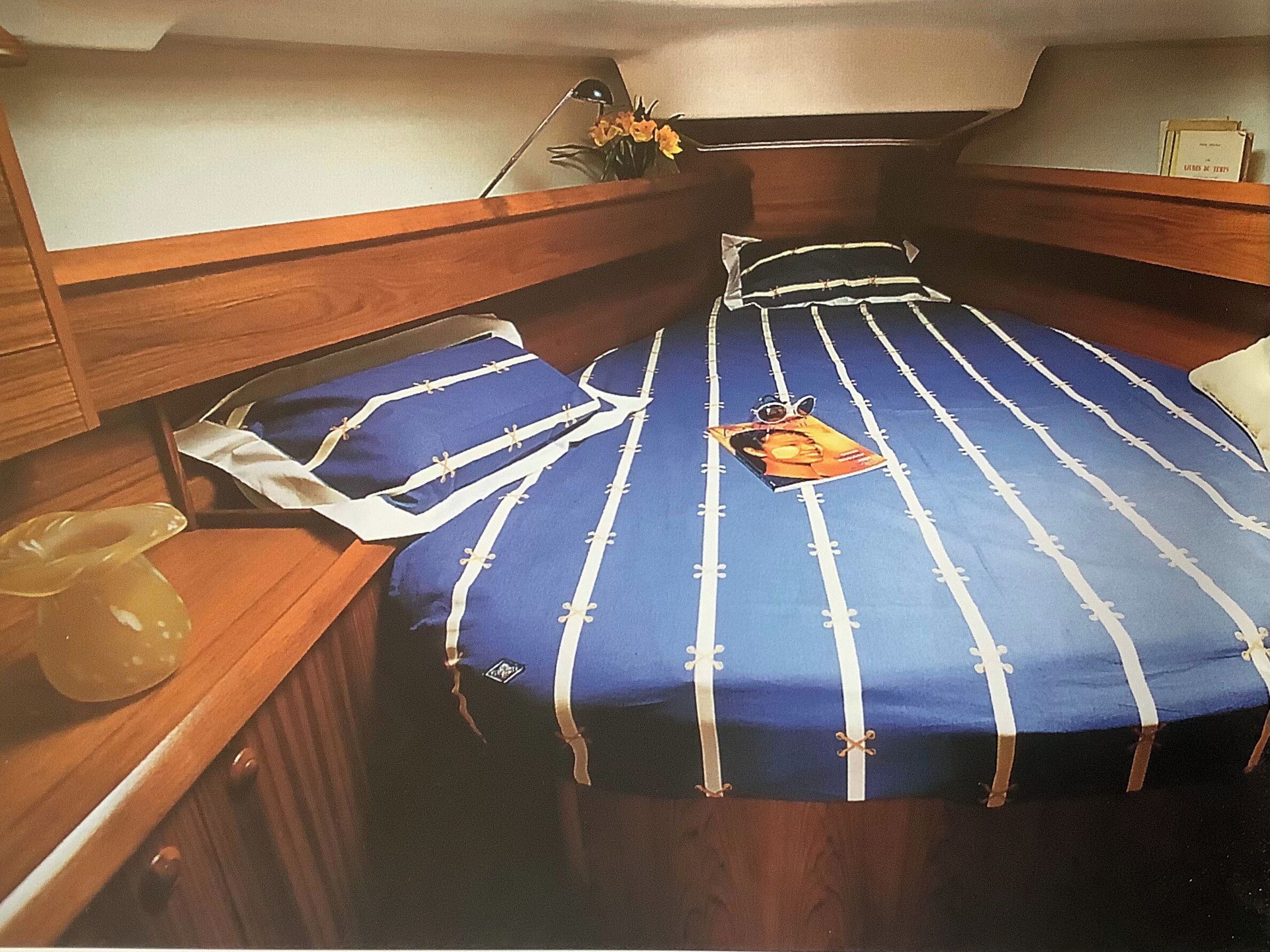 Um quarto compacto com beliche, uma mesa pequena com um vaso e um espelho.