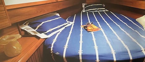 Una cabaña pequeña con una cama individual, una mesa con un florero y un espejo.