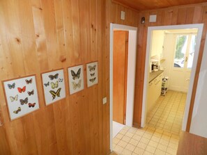 Interior em madeira com um corredor que leva a uma cozinha.
