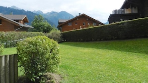 Un barrio residencial con casas, un césped cuidado y montañas al fondo.