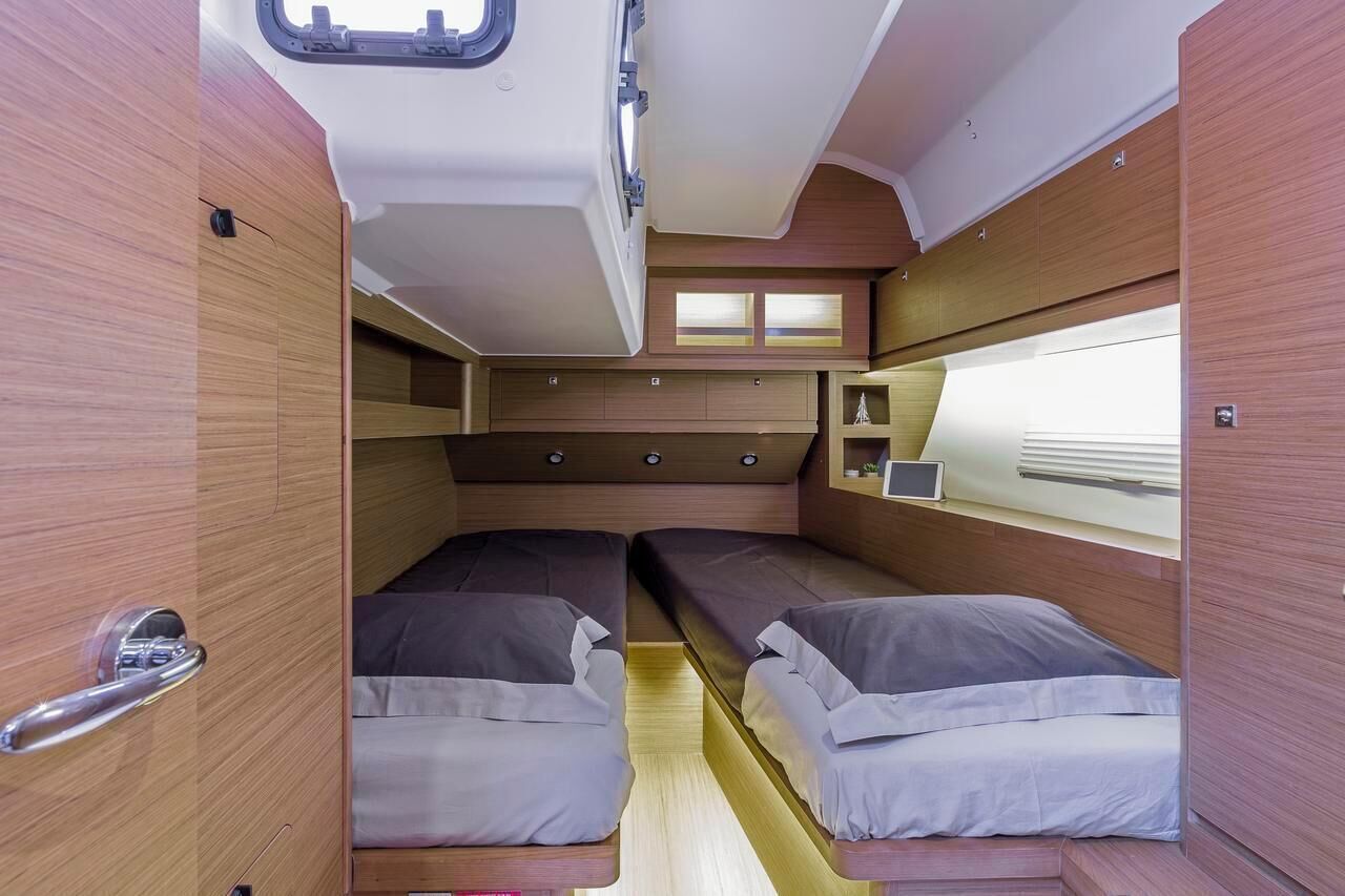 A compact interior with two beds, a small window, and built-in storage.