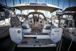 Un pont de bateau équipé d’un volant, d’une petite table et d’un panneau solaire.