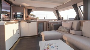 L'intérieur d'un yacht comprenant une cuisine, un coin repas et un canapé.