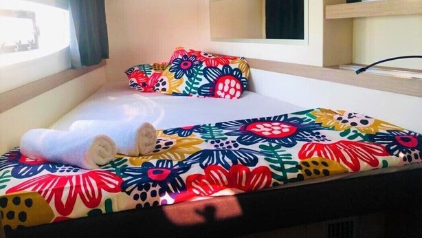 Une chambre d’hôtel avec un lit, une fenêtre, un miroir et une étagère.