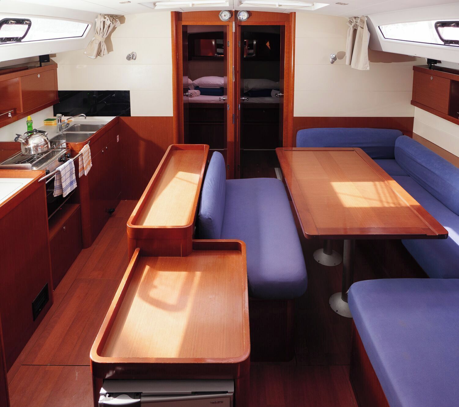 Un espacio interior compacto con kitchenette, una mesa de comedor y zona de estar.