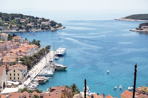 A coastal town with a marina, buildings with red-tiled roofs, and boats. - Sun-Kissed Sailing Adventure in Split, Croatia (Rogac)