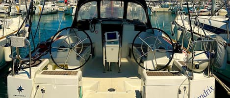 A boat with a steering wheel, a control panel, and the name 'Hendrix' on the side.