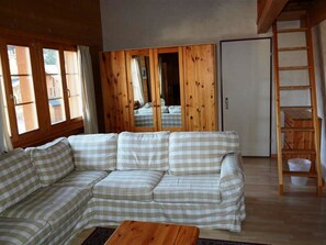 A living room with a checkered sofa, wooden wardrobe, and a wooden ladder. - Jacqueline 24 Appartement/Fewo, Dusche oder Bad, WC 5-Bettwohnung by Interhome (Gstaad)