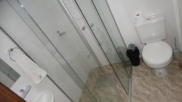 Een douche, handdoeken, zeep, toiletpapier
