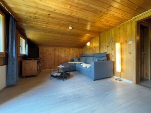 A wooden-paneled room with a sofa, a small table, and a television. - Sonnegg Appartement/Fewo, Dusche oder Bad, WC 5-Bettwohnung by Interhome (Gsteig bei Gstaad)
