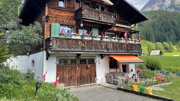 Eine Holzhütte mit Balkon, überdachter Veranda und Bergblick.