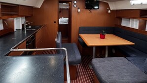 Ett kompakt pentry med ett stort matbord, sittplatser och ett litet kök.