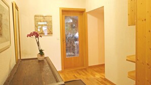 A wooden floor, a door with frosted glass, a framed picture, and a vase with flowers. - Pfander Appartement/Fewo, Dusche und Bad, WC, 3 Schlafräume 7-Bettwohnung by Interhome (Zweisimmen)