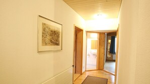 A hallway with a radiator, a framed picture, and a door leading to a bathroom. - Pfander Appartement/Fewo, Dusche und Bad, WC, 3 Schlafräume 7-Bettwohnung by Interhome (Zweisimmen)