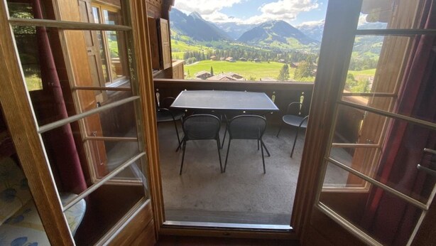 A balcony with a table and chairs, offering a view of a mountainous landscape. - Sonnige Matte Appartement/Fewo, Dusche oder Bad, WC 8-Bettwohnung by Interhome (Gstaad)