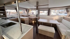 Eine kleine Küche mit Spüle, Herd und Essbereich mit einer Bank und einem Tisch.