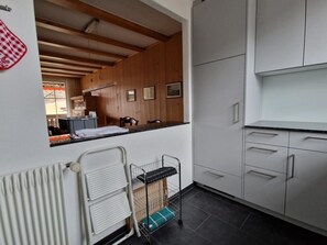 A modern kitchen with white cabinets, a wooden ceiling, and a small dining area. - Oberland Nr. 19 Appartement/Fewo, Dusche oder Bad, WC 6-Bettwohnung by Interhome (Gstaad)