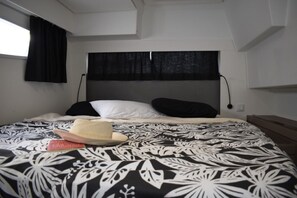 A bedroom with a patterned bedspread, a hat, and a book on the bed. - Sun-kissed Sailing Adventure in Split-Dalmatia, Croatia (Seget Donji)