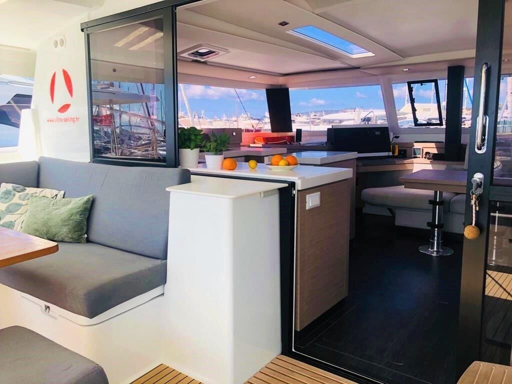 Een modern interieur met een bank, een kitchenette en stadszicht door grote ramen.