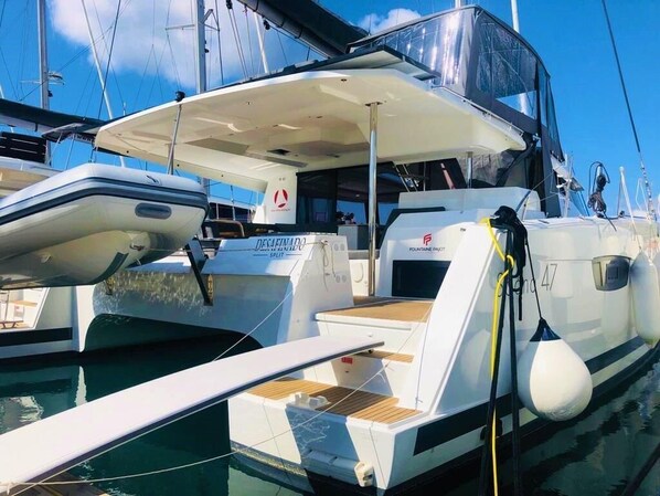 A marina with boats docked, including a white yacht with a cabin and a deck area. - Sun-kissed Sailing Adventure in Split-Dalmatia, Croatia (Seget Donji)