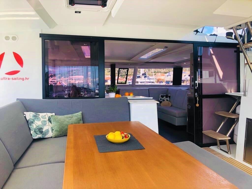 Un interior moderno con sofá, mesa de comedor y vistas a través de un ventanal.