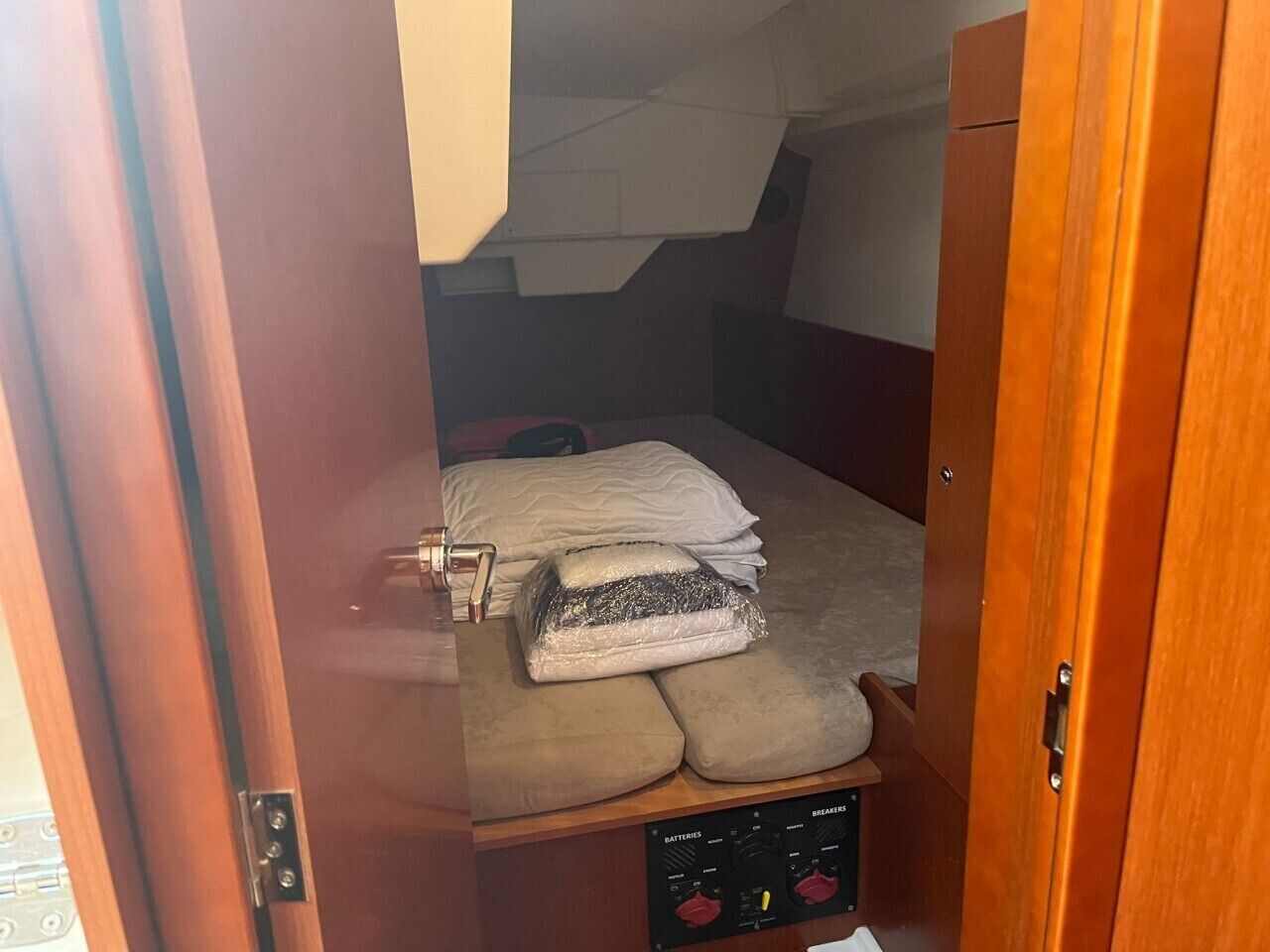 A compact room with a bunk bed, a control panel, and a storage cabinet.