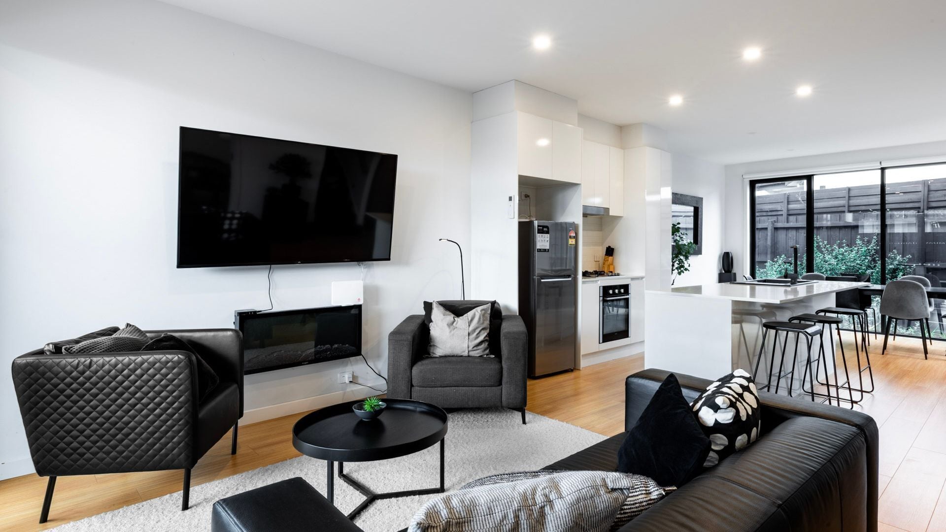 A modern living room with a flat-screen TV, sofa, and coffee table.