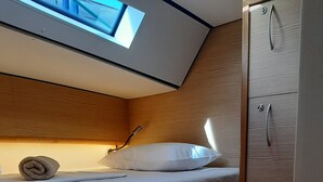 A bunk bed room with a skylight, wooden walls, and a wardrobe. - Sun-kissed Sailing Adventure in Split-Dalmatia, Croatia (Trogir)