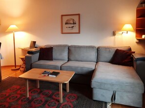 A living room with a grey sofa, a wooden coffee table, and two floor lamps. - Mösli (Zimmerli) Appartement/Fewo, Dusche oder Bad, WC 2-Bettwohnung by Interhome (Zweisimmen)