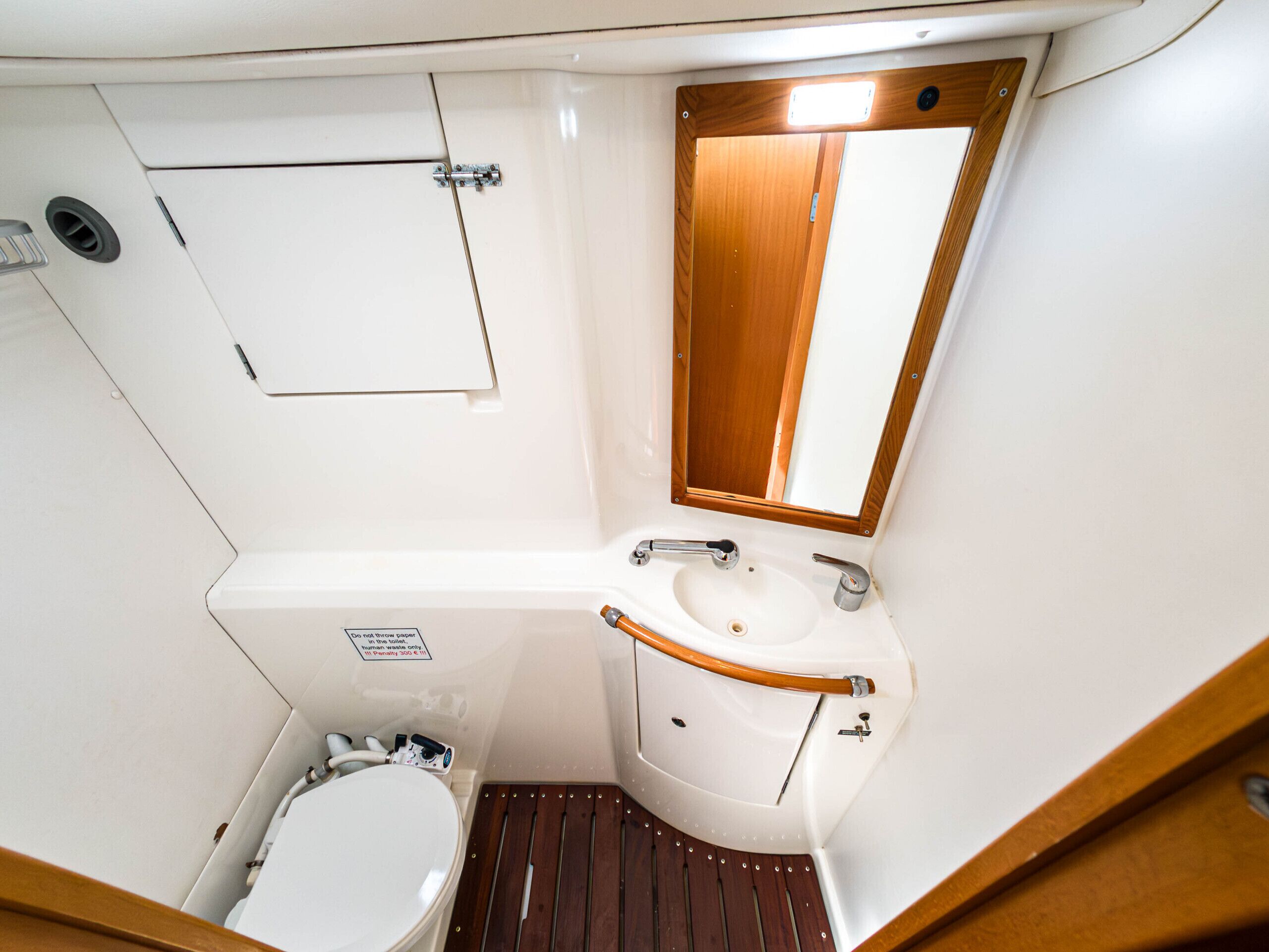 Une petite salle de bain comprenant des toilettes, un lavabo et un miroir.