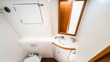 Une petite salle de bain comprenant des toilettes, un lavabo et un miroir.