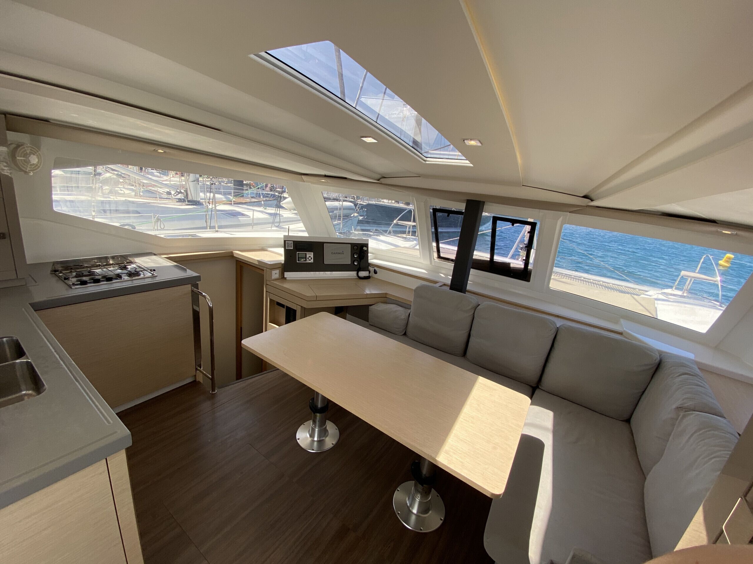 L’intérieur d’un yacht comprenant une cuisine, un coin salon et une vue sur le port de plaisance.
