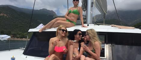 A group of people on a boat with a mountainous landscape in the background.