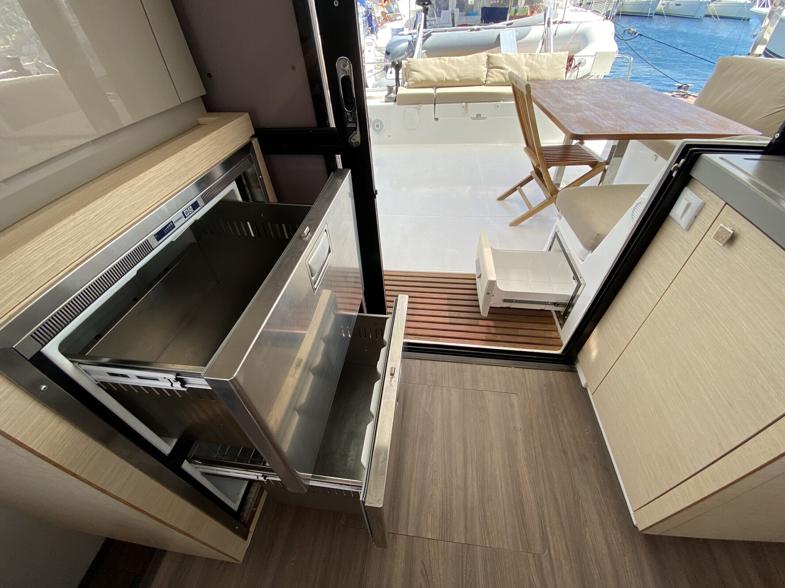 Una cocina pequeña y funcional con estufa de acero inoxidable, un lavamanos y una mesa de madera con sillas.